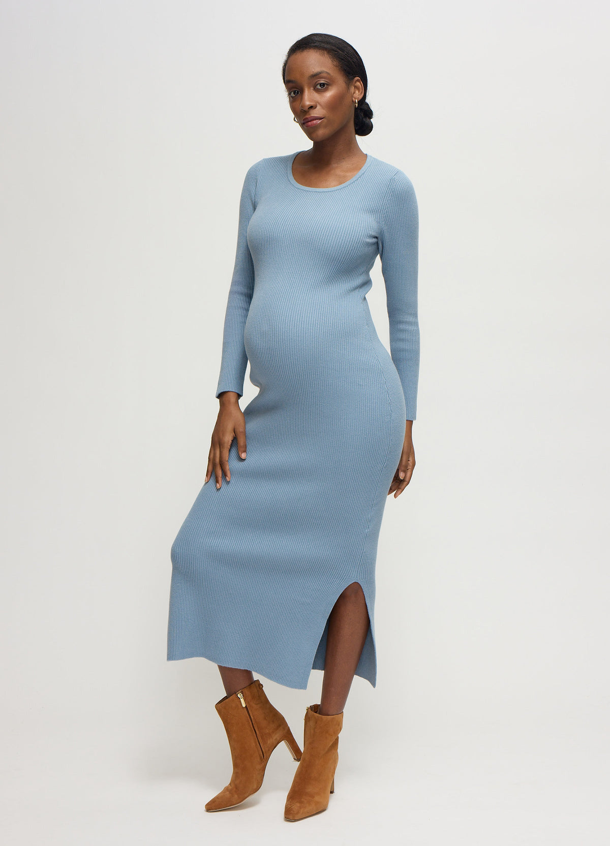 ||A pregnant woman wearing a blue gray long-sleeve ribbed sweater maternity midi dress with tan suede boots